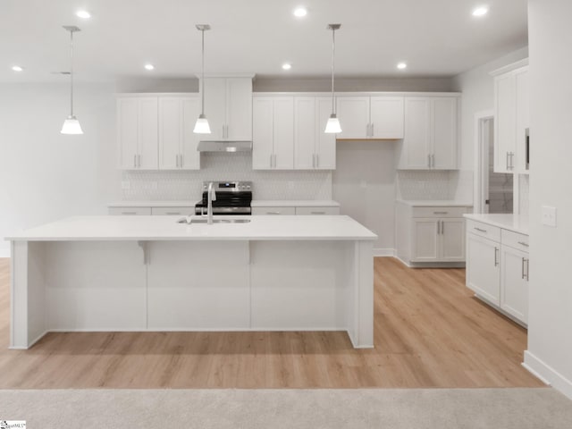 kitchen featuring white cabinetry, an island with sink, and decorative light fixtures