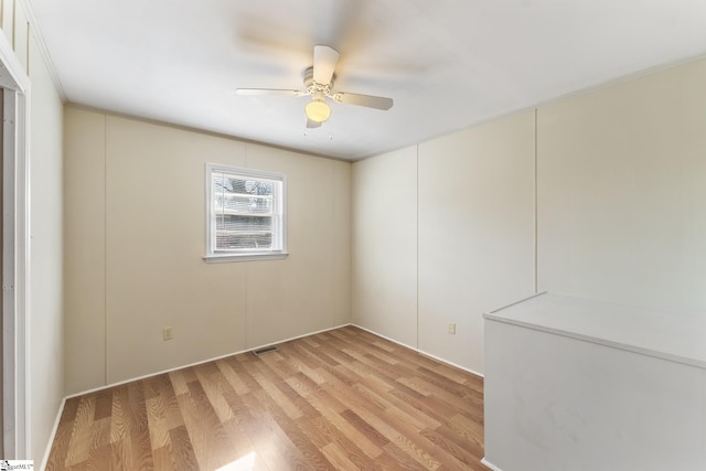 empty room featuring light hardwood / wood-style flooring, ceiling fan, and ornamental molding