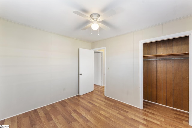 unfurnished bedroom featuring ceiling fan, a closet, and light hardwood / wood-style flooring