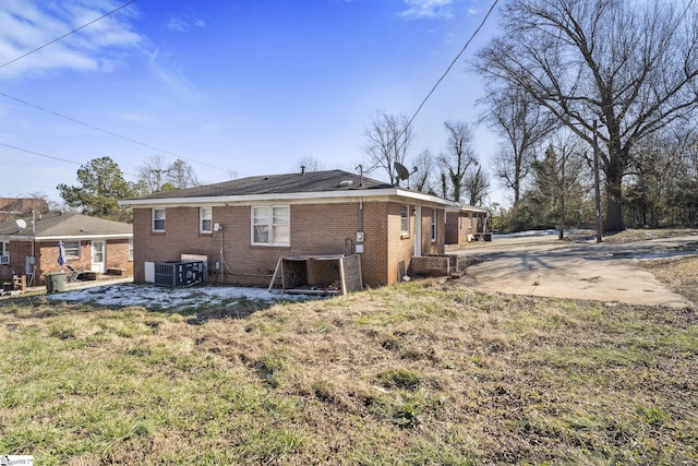 back of property featuring central AC and a yard