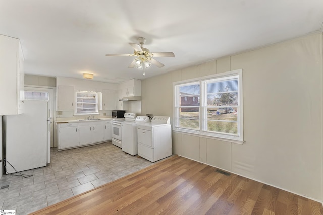 laundry area featuring washing machine and dryer, light hardwood / wood-style floors, ceiling fan, and sink