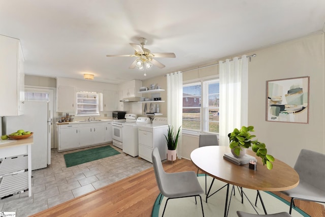 dining space with ceiling fan, light wood-type flooring, sink, and separate washer and dryer