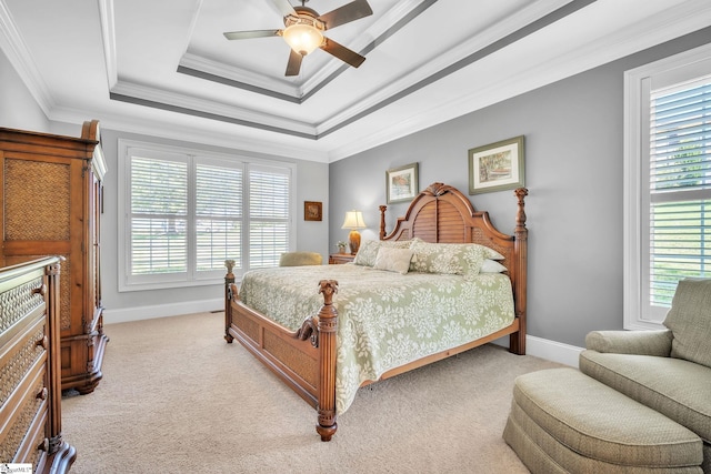 bedroom with ceiling fan, a raised ceiling, crown molding, and light carpet