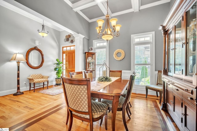 dining space with coffered ceiling, light wood-type flooring, ornamental molding, beamed ceiling, and a chandelier