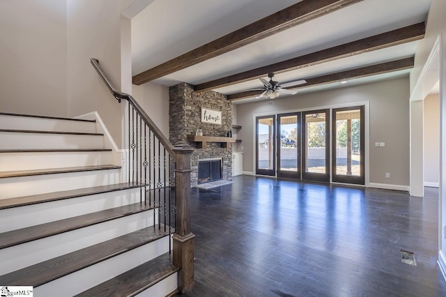 unfurnished living room featuring beam ceiling, dark hardwood / wood-style flooring, ceiling fan, and a fireplace