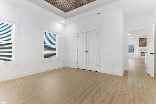 unfurnished bedroom with multiple windows, light hardwood / wood-style flooring, and a closet