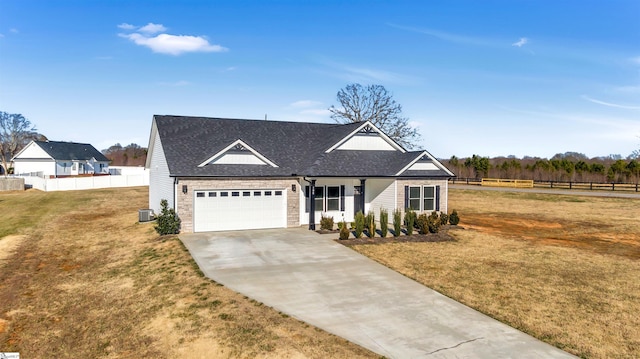 view of front of house featuring a garage, a front lawn, and central air condition unit