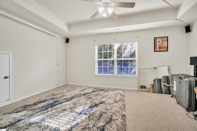 interior space featuring carpet flooring, ceiling fan, and a tray ceiling