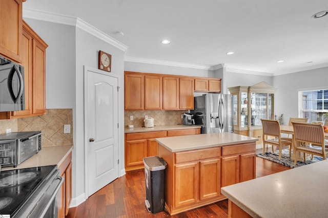 kitchen featuring tasteful backsplash, crown molding, a center island, and appliances with stainless steel finishes