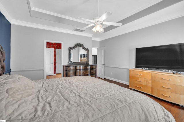 bedroom with dark hardwood / wood-style floors, a raised ceiling, ceiling fan, and ornamental molding