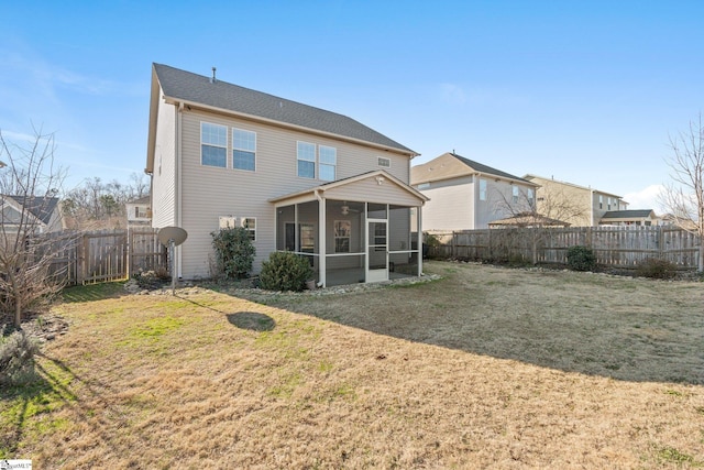 back of property with a sunroom and a yard