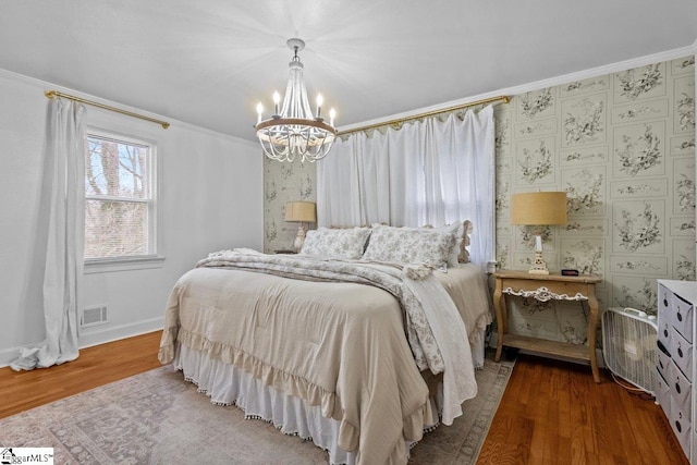 bedroom featuring a notable chandelier, hardwood / wood-style floors, and ornamental molding