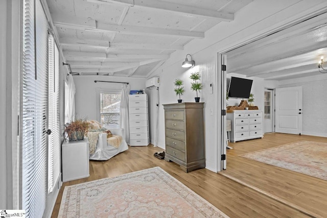 interior space featuring vaulted ceiling with beams, a wall mounted air conditioner, and light hardwood / wood-style flooring