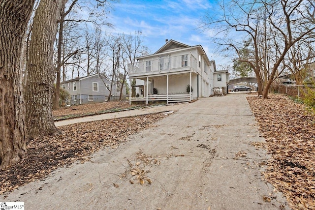 front of property featuring a porch and a balcony