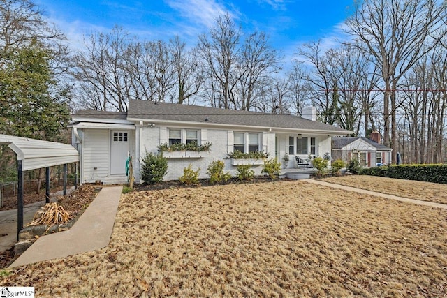 ranch-style home with a porch, a carport, and a front lawn