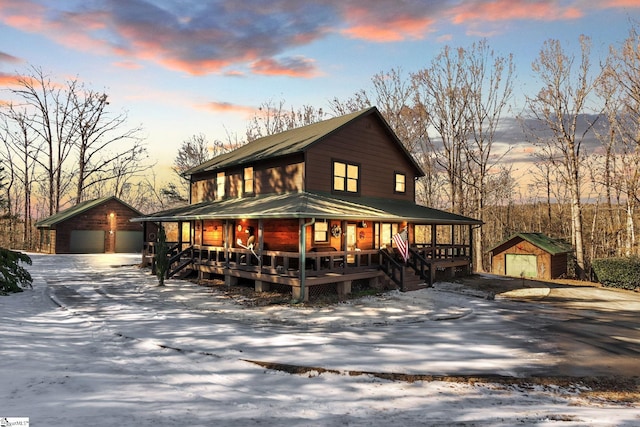 view of front of home featuring a garage, an outbuilding, and covered porch