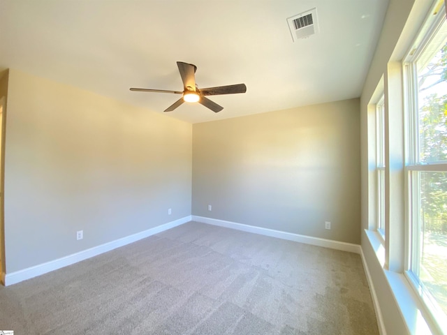 empty room with carpet, ceiling fan, and plenty of natural light