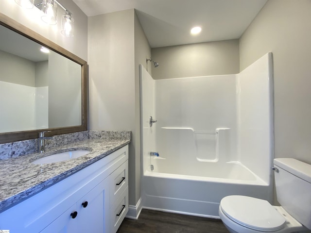 full bathroom featuring vanity, toilet, washtub / shower combination, and wood-type flooring