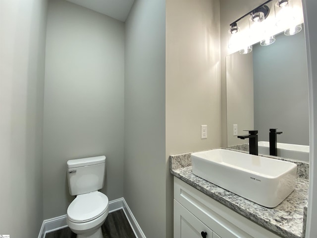 bathroom featuring toilet, vanity, and hardwood / wood-style flooring