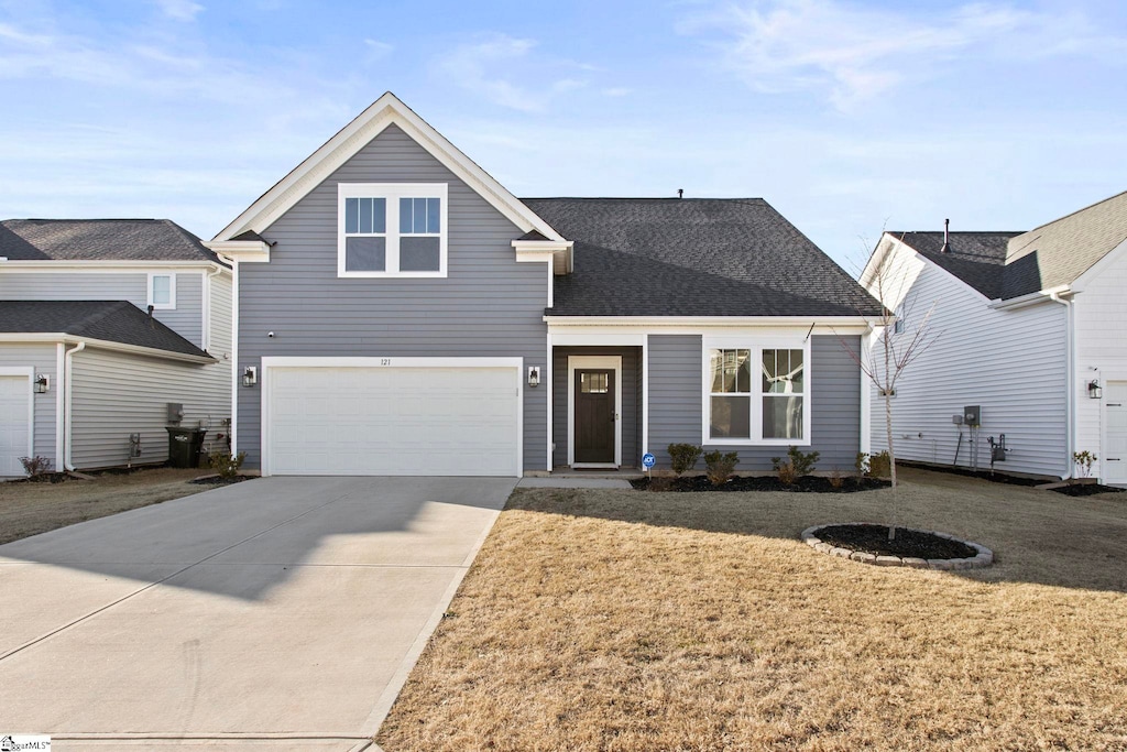 view of front of house featuring a garage and a front lawn