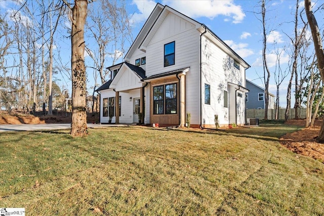 modern farmhouse with central AC unit and a front yard