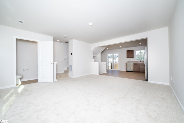 unfurnished living room with lofted ceiling and light colored carpet