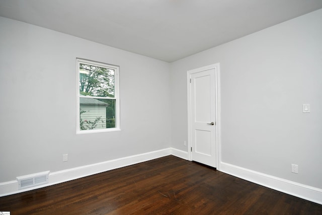 spare room with dark wood-type flooring