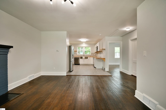 unfurnished living room featuring sink and light wood-type flooring