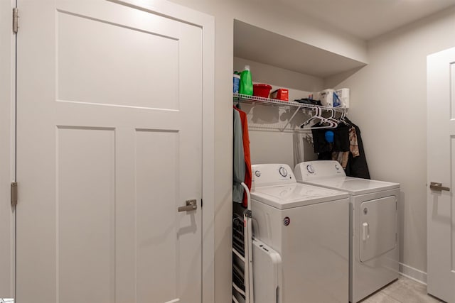 washroom with independent washer and dryer and light tile patterned flooring