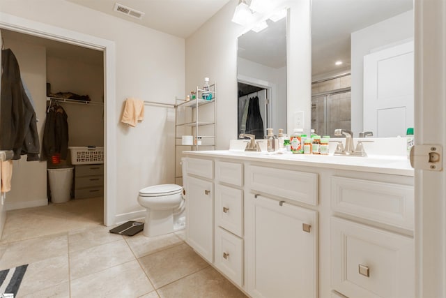 bathroom with tile patterned floors, an enclosed shower, vanity, and toilet