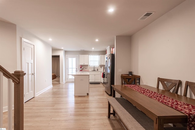 dining space with light hardwood / wood-style floors and sink