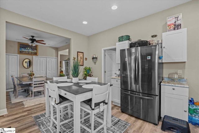 dining area featuring light wood-type flooring and ceiling fan