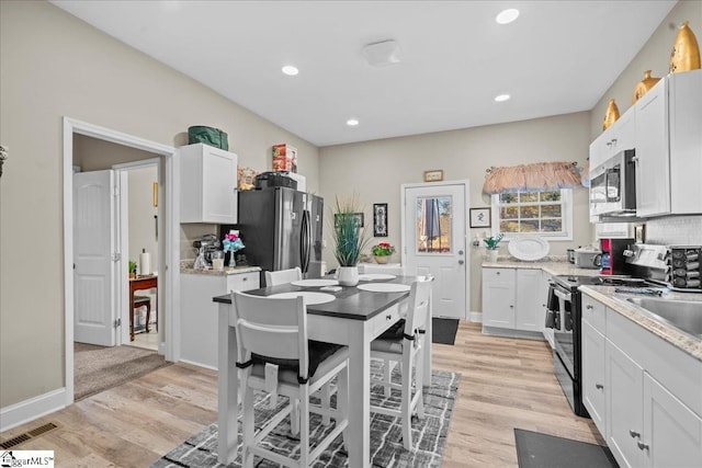 kitchen featuring sink, appliances with stainless steel finishes, light hardwood / wood-style flooring, and white cabinetry