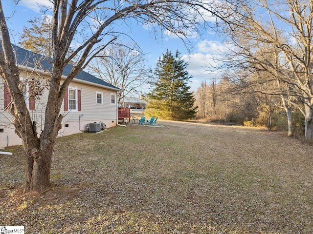 view of yard featuring central air condition unit and a deck