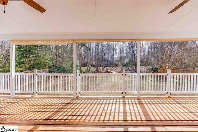 unfurnished sunroom featuring ceiling fan