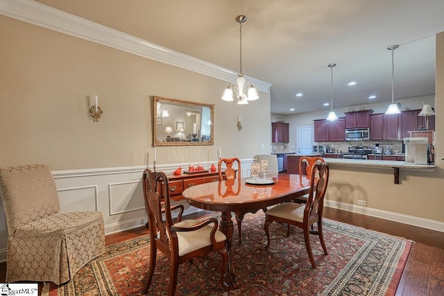 dining area featuring dark hardwood / wood-style flooring, crown molding, and a notable chandelier