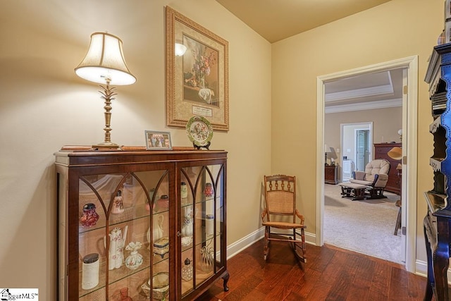 sitting room with ornamental molding and dark hardwood / wood-style floors