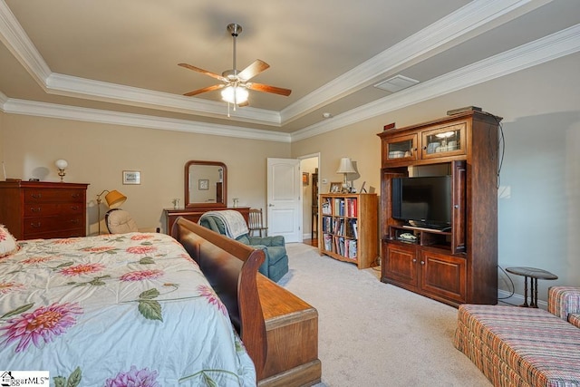 carpeted bedroom with ceiling fan, ornamental molding, and a tray ceiling