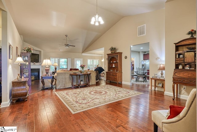 living room featuring ceiling fan with notable chandelier, high vaulted ceiling, and wood-type flooring