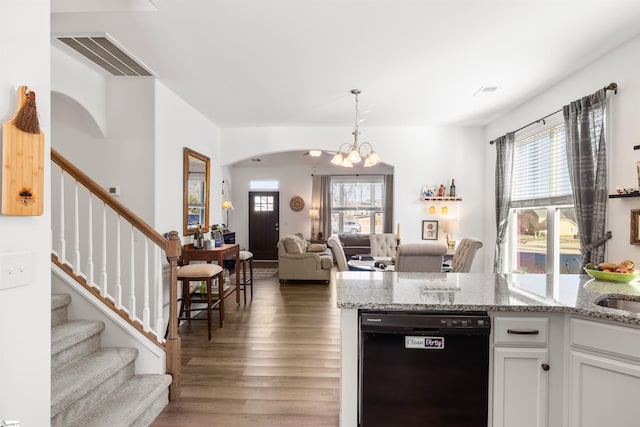 kitchen with light stone counters, dishwasher, pendant lighting, a healthy amount of sunlight, and white cabinets