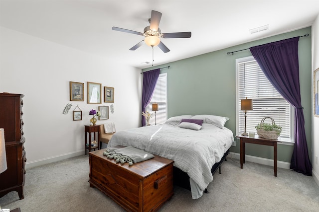 carpeted bedroom with ceiling fan and multiple windows