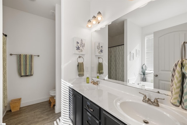 bathroom featuring walk in shower, hardwood / wood-style floors, vanity, and toilet