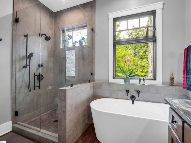 bathroom with separate shower and tub, wood-type flooring, and vanity