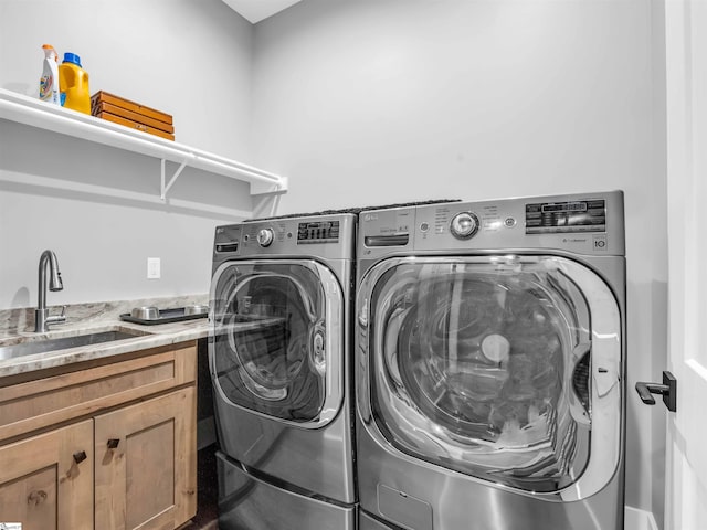 laundry room featuring cabinets, washing machine and clothes dryer, and sink