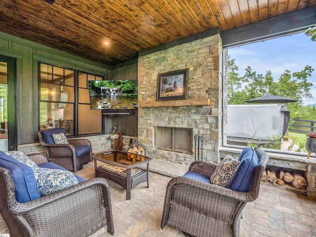 sunroom / solarium with wooden ceiling and an outdoor stone fireplace