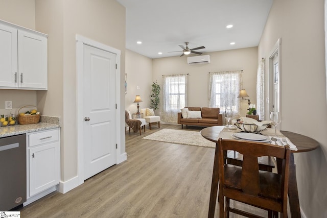 dining space featuring ceiling fan, light hardwood / wood-style floors, and a wall mounted air conditioner