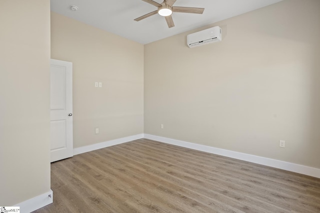 spare room with an AC wall unit, ceiling fan, and light hardwood / wood-style flooring