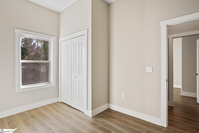 unfurnished bedroom featuring a closet and hardwood / wood-style floors