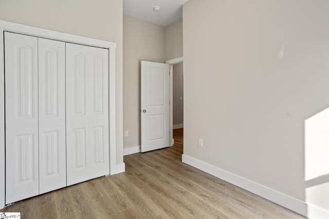 unfurnished bedroom featuring a closet and light wood-type flooring