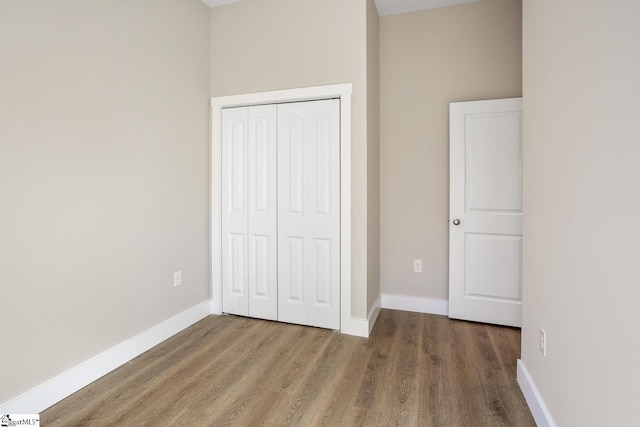 unfurnished bedroom with a closet and hardwood / wood-style flooring